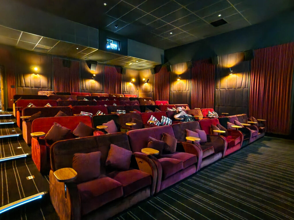 Comfy seats with cushions and side tables at Wokingham Everyman cinema