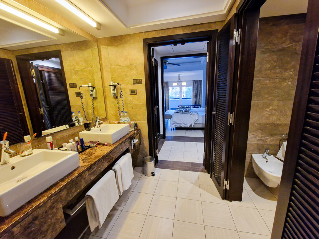 Twin Pool View room. Bathroom with his and her sink, toilet and bidet 