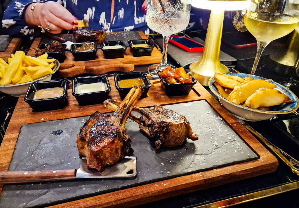 Lamb cutlets served blue cheese dip, peppercorn sauce and caramelised onion and potato wedges on the side