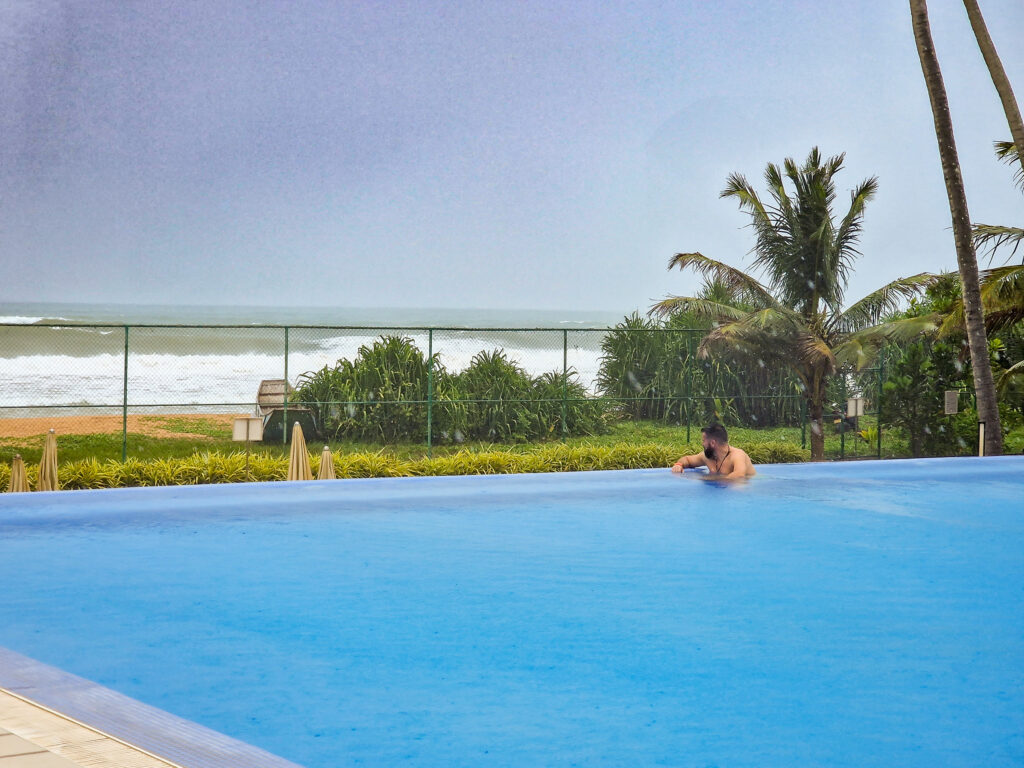 Luke sitting in the swimming pool looking out to the sea at the riu sri lanka