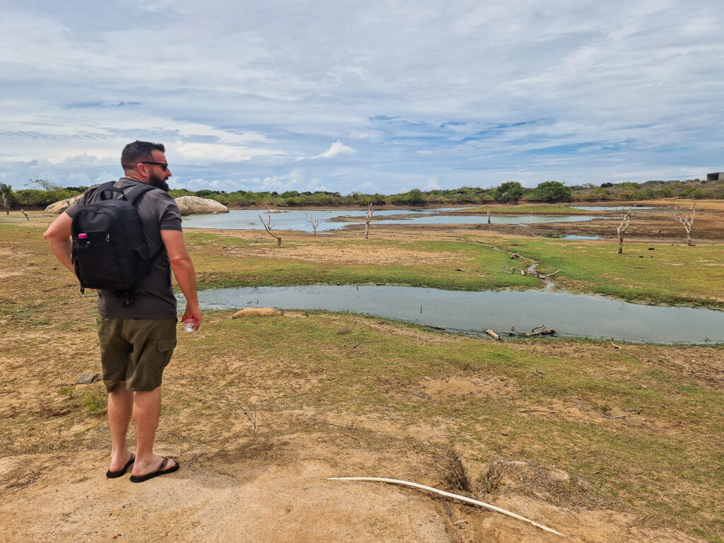 Luke standing looking out at the lake next to Wild Cinnamon Yala where there are wild crocodiles