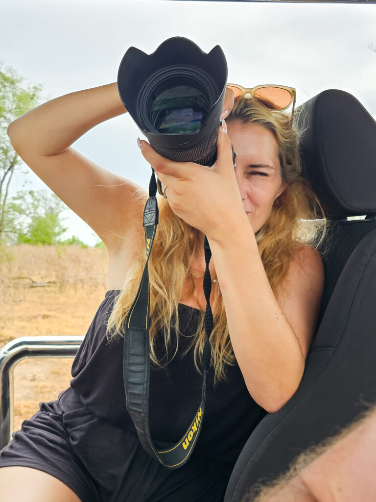 Kay from flawless journeys taking pictures with her camera on the back of a safari jeep at Udawalawe National Park