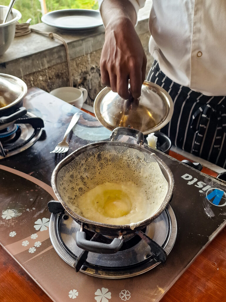 An egg hopper being cooked for breakfast at 98 acres hotel in Ella Sri Lanka