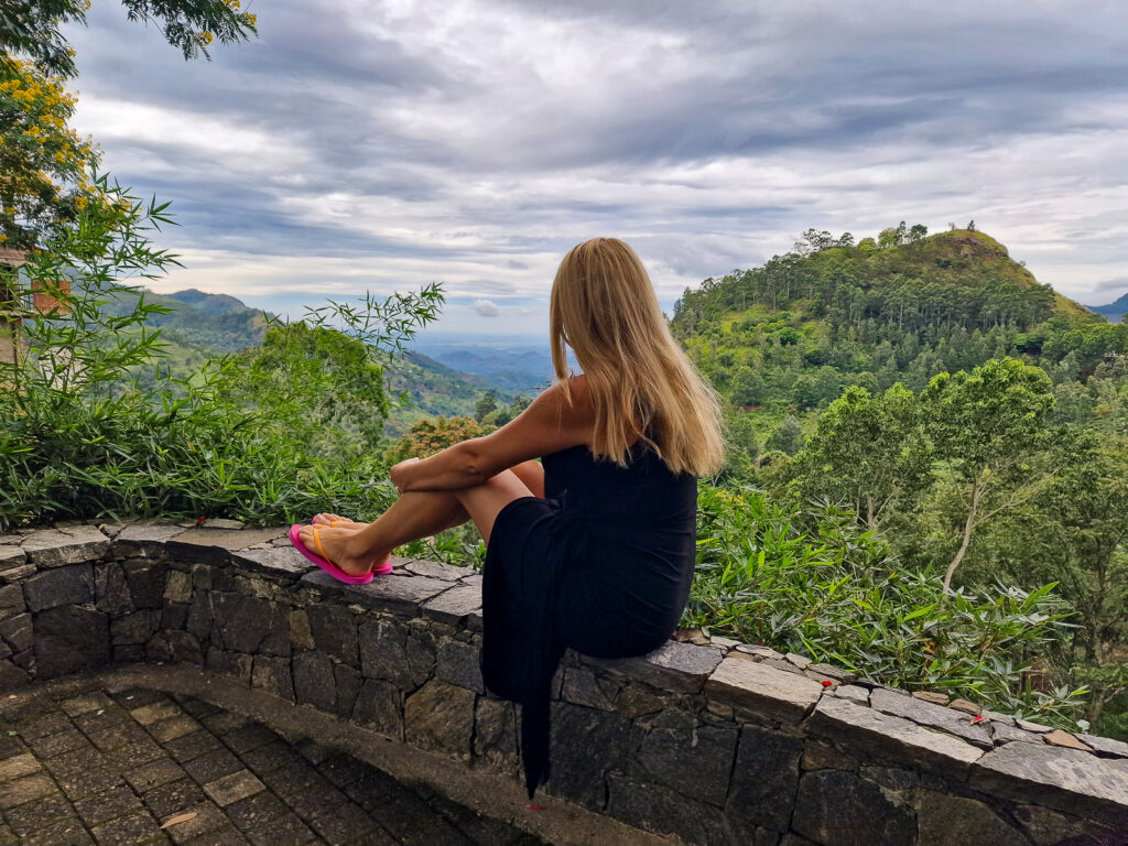 Kay sitting on a wall looking the beautiful views from 98 Acres Resort
