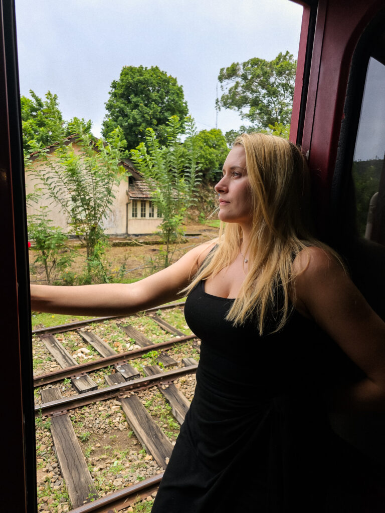 Kay standing in the open doorway on the Ella Train Ride in Sri Lanka
