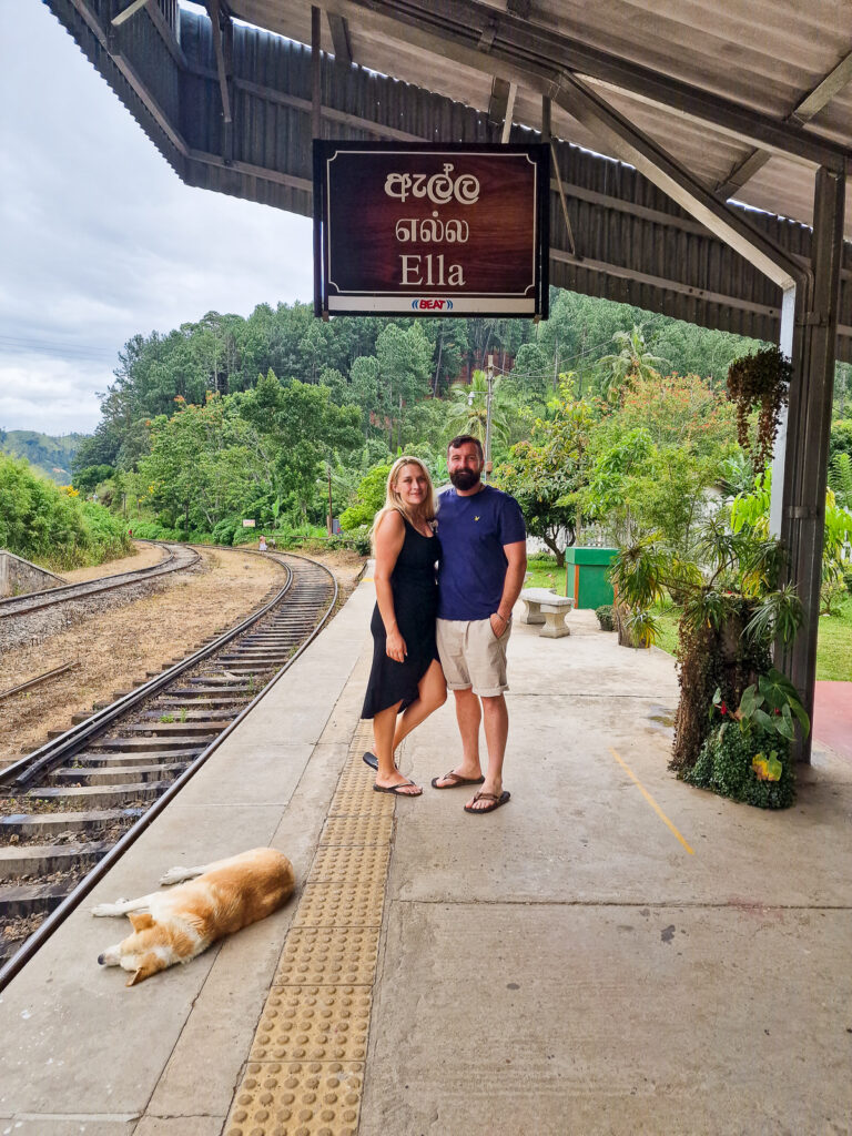 Luke and Kay from Flawless Journeys on the Ella Train station platform with a sleeping dog also on the platform