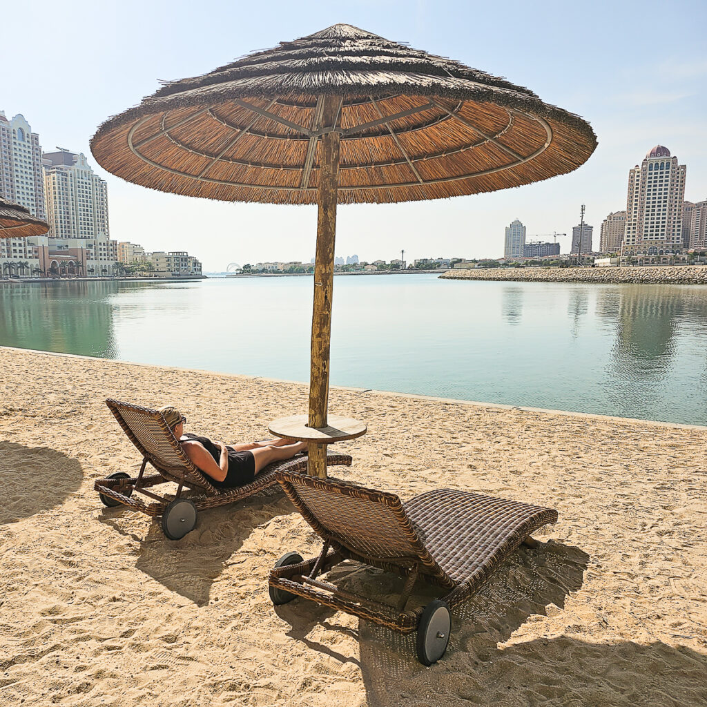 Kay laying on a sun lounger at Bahriya Beach at The Pearl Qatar Doha